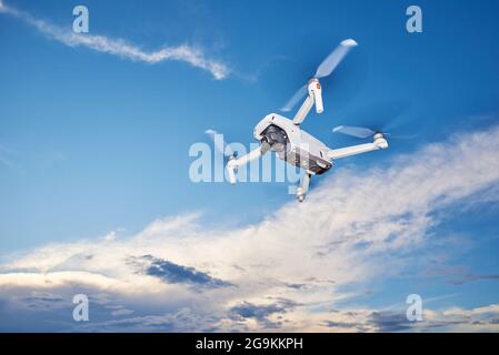 Modern drone with camera in the sky. Flying quadcopter Stock Photo