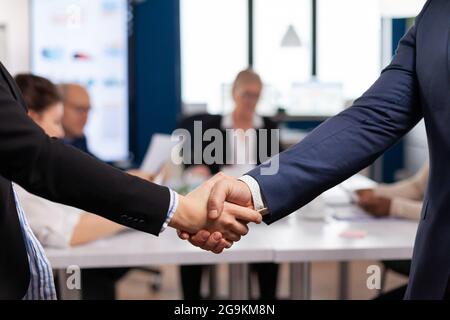 Satisfied businessman company employer wearing suit handshake new employee get hired at job interview, Man hr manager employ successful candidate shake hand at business meeting, placement concept Stock Photo