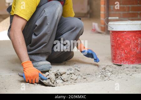 Close up of a young caucasian construction worker shoveling sand at a construction site. Stock Photo