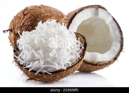 Coconut fruit and shredded coconut flakes in the piece of shell isolated on white background. Stock Photo