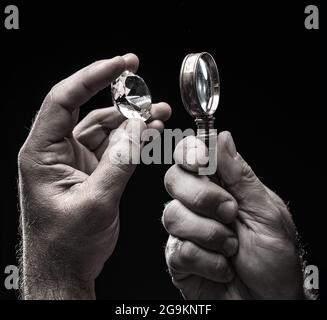 Large gemstone in jeweler's hand close up. Gem identifying and evaluating process. Stock Photo