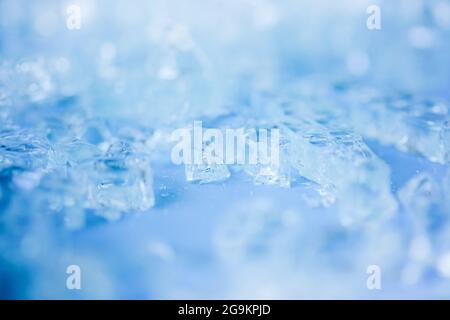Selective focus,blurred photo of broken pieces of glass on blue background. Abstract minimalistic concept. Space for text . Stock Photo