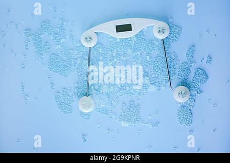 Broken digital human scale on the floor for measuring people.Cracked weight scales on blue background. Weight measurement and control. Concept of over Stock Photo