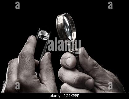 Large gemstone in jeweler's hand close up. Gem identifying and evaluating process. Stock Photo