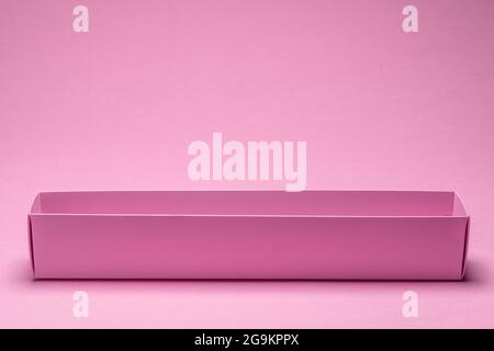 Empty open paper package box on pink background. Stock Photo