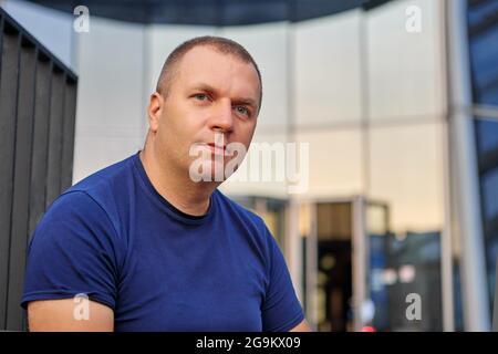 Pensive caucasian man sits near business center. Stock Photo
