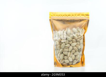 Pistachio nuts in window pouch packaging with uncleared plastic, zip-lock on top, gold colour packaging. Front view with blank space for a design labe Stock Photo
