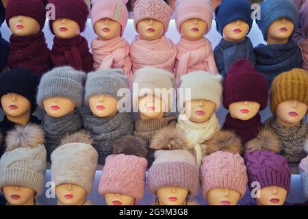 Winter and autumnal warm hats on mannequins in a shop window Stock Photo