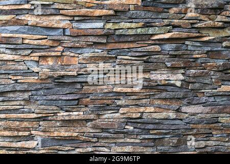 Stone wall background. Rock texture. Abstract pattern. Natural backdrop. Gray tiles of the building facade. Architecture element, vintage design. Bric Stock Photo