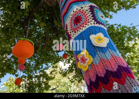 Colorful crochet knit tree trunk (yarn bombing) Stock Photo