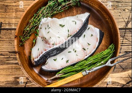 Raw Blue Shark steaks in a wooden plate. wooden background. Top view Stock Photo