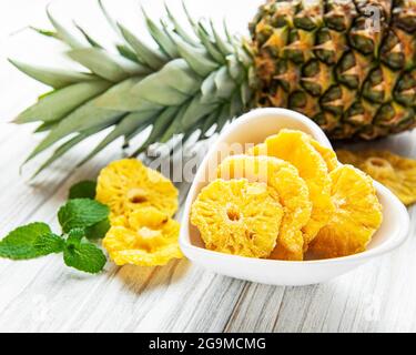 Pineapple dried rings on rustic wooden background Stock Photo