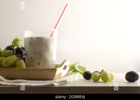 Organic grape drink on try with bunches of white and red grapes in try on wooden table isolated background. Front view. Stock Photo
