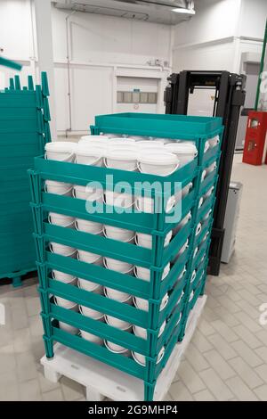 Finished food products in plastic white buckets on pallets. Stock Photo