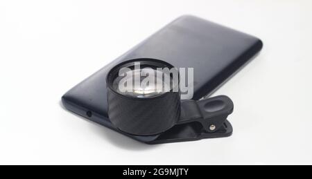 Lensbong attached to smartphone, Lensa Bongkaran, Additional Lens for close up or macro photography at white background Stock Photo
