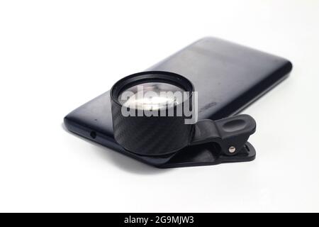 Lensbong attached to smartphone, Lensa Bongkaran, Additional Lens for close up or macro photography at white background Stock Photo