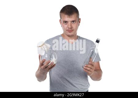 Photo of young man with bristle holding sugar and empty glass bottle Stock Photo