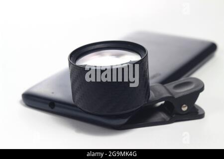 Lensbong attached to smartphone, Lensa Bongkaran, Additional Lens for close up or macro photography at white background Stock Photo