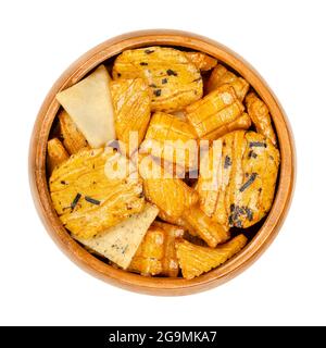 Senbei, Japanese rice crackers, in a wooden bowl. Also sembei, crispy, bite-sized and savory snacks, in various shapes and sizes, slightly salted.