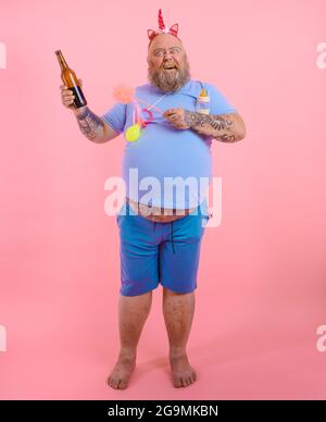 Fat happy man acts like a happy baby but drinks beer Stock Photo