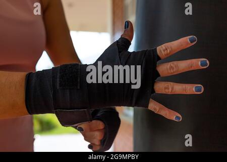 Close-up of fit, young woman putting boxing wraps or bandage on her hands Stock Photo