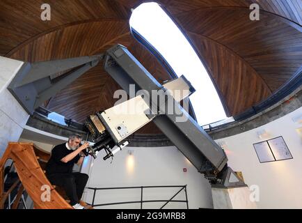 Papal astronomer the Jesuit Brother Guy Consolmagno director of the Vatican Observatory since 2015, is looking through the ‘Carte du Ciel’ telescope a 19th century model with a focal of 360cm on June 2021 at the headquarters of the ‘Specola Vatican’ (Vatican Observatory) in Castel Gandolfo, Italy, on June 14, 2021. The Vatican Observatory, one of the oldest astronomical research institutions in the world, has its headquarters at the papal summer residence in Castel Gandolfo, outside Rome. For the first foreshadowing of the Observatory can be traced to the constitution by Pope Gregory XIII of a Stock Photo