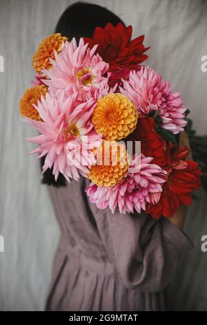 Beautiful Woman Holding Colorful Dahlias Flowers In Rustic Room 