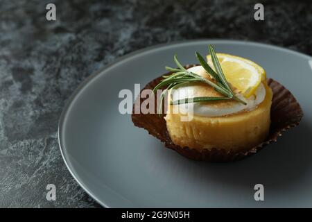 Plate with lemon cupcake on black smokey table Stock Photo