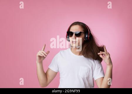 man in sunglasses listens to music with headphones and dances Stock Photo