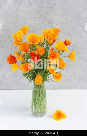 Bouquet of bright orange flowers in vase on background gray stone wall. Template for postcard. Concept Women's day, Mothers Day, Hello summer or Hello Stock Photo