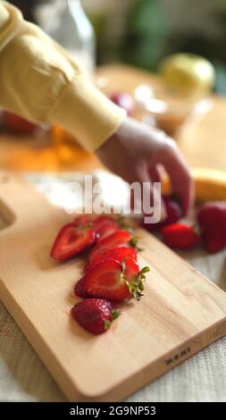 A woman is cooking with strawberries Stock Photo