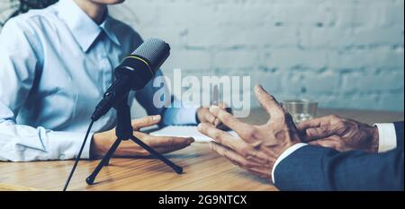 podcast interview recording - radio host discussion with businessman in broadcasting studio. banner copy space Stock Photo