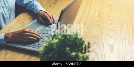 business woman using laptop computer on wooden table. work from home, freelance job. banner copy space Stock Photo