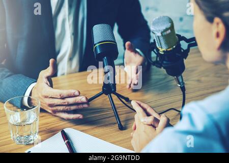 radio interview, podcast recording - business people talking in broadcasting studio Stock Photo