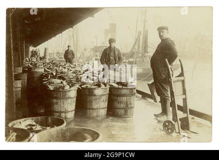 Early 1900's image of fishmongers at the old Billingsgate Fish Market, with a huge quantity of fish in crates, London, U.K.  circa 1910 Stock Photo