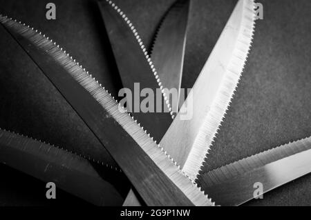 kitchen knife blades on dark gray background, black and white image, abstract background Stock Photo