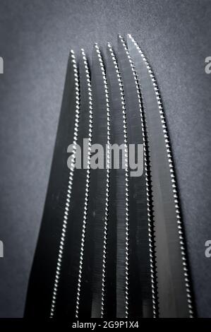 kitchen knife blades on dark gray background, black and white image, abstract background Stock Photo