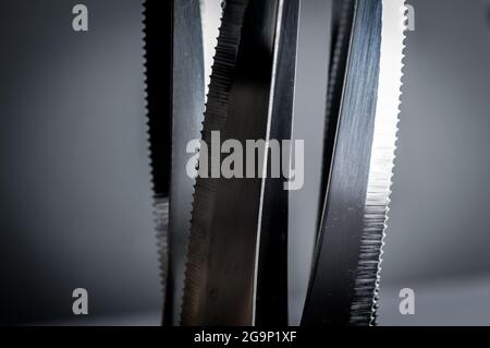 kitchen knife blades on dark gray background, blue toned image, abstract background Stock Photo