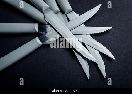 kitchen knife blades on dark gray background, blue toned image, abstract background Stock Photo