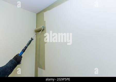 Painting walls, industrial worker using roller for painting Stock Photo