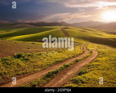 scenic path through the rolling hills at the sunset Stock Photo
