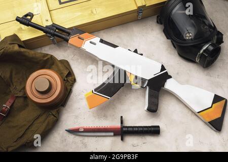 Wooden toy machine gun and bayonet knife on the table, top view Stock Photo