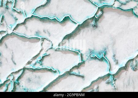 White-turquoise texture of Pamukkale calcium travertine in Turkey, uneven pattern of big cells Stock Photo