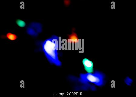 colored bokeh lights sparkling on black background Stock Photo