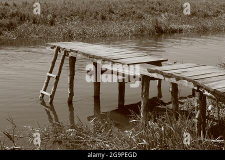 monochrome old photo of village pond and wooden bridge Stock Photo