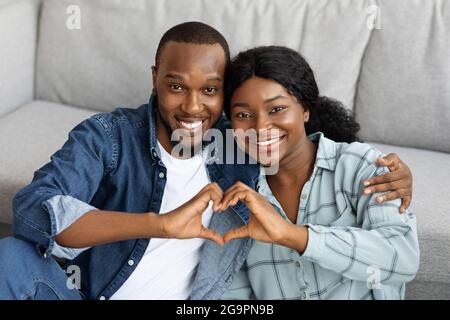 Portrait Of Joyful Romantic African American Couple Making Heart Gesture At Camera Stock Photo