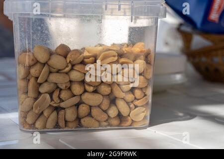 Closeup shot of peeled peanuts in a plastic container Stock Photo