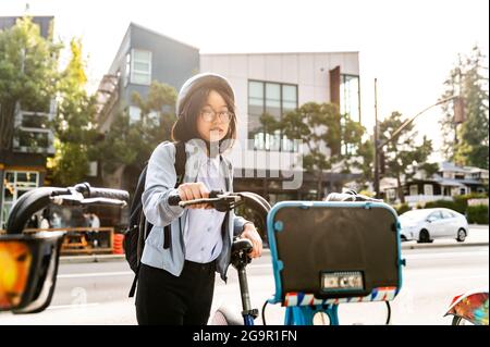 Young professional using bike share in urban setting Stock Photo