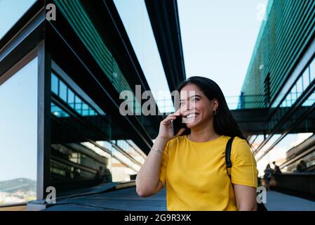 Woman talking on the phone in front of a corporate building Stock Photo