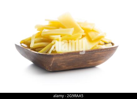 Sliced canned bamboo shoots in wooden bowl isolated on white background. Stock Photo